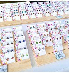 several rows of earrings are on display at the store's counter top, with price tags attached to them