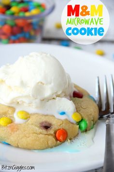 a close up of a cookie on a plate with ice cream and m & m