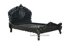 an ornate black bed frame with intricate carvings