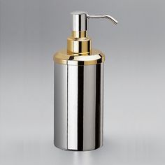 a silver and gold soap dispenser on a gray background