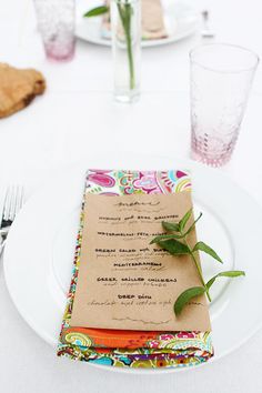 a place setting with napkins, silverware and flowers