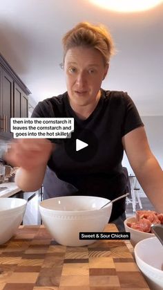 a woman is cooking in the kitchen with bowls and spoons on the counter top