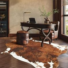 a cowhide rug is on the floor next to a desk