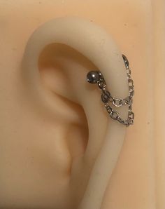 Hand made stainless steel ear jacket cartilage piercing ear piercing chain ⛓ Hand Made in standard length (2.8cm)but can be made longer or shorter for personal needs! Made for cartilage piercings but can be used for lobe, helix and forward helix piercings *does not fit conch piercings* please see other listings for conch chains 📷Photos are reference of size and placement, the chain hooks on under studs or through hoops but please be aware they do NOT come with the hoops or studs included unless you select the in the options to include a stud, these are made to attach to existing piercing jewellery- top listing is for chain only or you can select chain with a stud we have silver studs, black, gold and rainbow are now available! All studs are plain ball top labrets measuring 1.2x8mm -standa Forward Helix Piercings, Helix Chain, Cuff Piercing, Piercing Chain, Ear Cuff Piercing, Conch Piercings, Ear Lobe Piercings, Helix Jewelry, Helix Ear