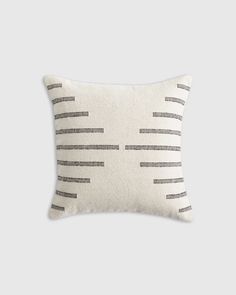 a white and black striped pillow on a gray background, with horizontal lines drawn across it