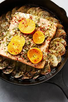 fish with orange slices and spices in a skillet