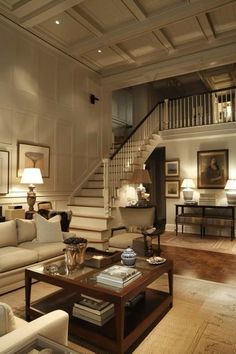 a living room filled with lots of furniture and a staircase leading up to the second floor