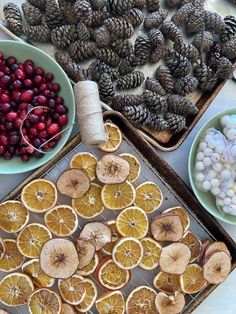 various fruits and vegetables are displayed on trays with pine cones, cherries, nuts, and other items