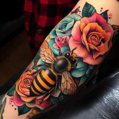 a woman's arm with flowers and a bee on it