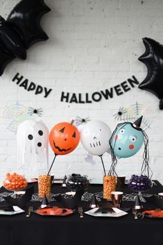 a table topped with halloween decorations and balloons