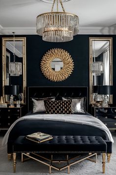 a bedroom with black walls, gold accents and a chandelier above the bed