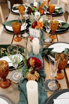 the table is set with candles, plates and napkins