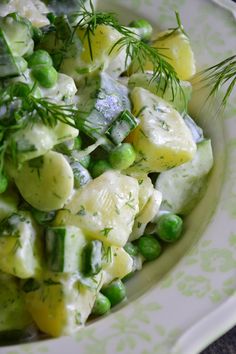 a white bowl filled with pasta and peas