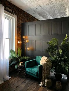 a living room with a green couch and potted plants on the floor next to a window