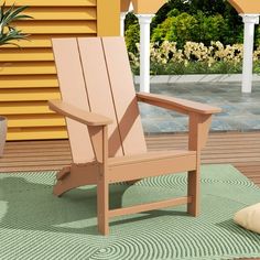 a wooden chair sitting on top of a green rug next to a potted plant