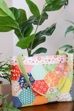 a potted plant sitting on top of a table next to a colorful patchwork bag