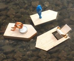 three pieces of wood sitting on top of a body of water next to each other