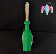 a green bottle sitting next to a pair of scissors on top of a black surface