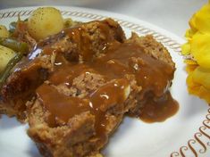 meatloaf with gravy, potatoes and green beans on a plate