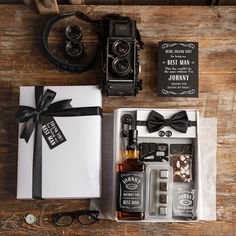 an old fashioned camera and other items are on the table next to a gift box