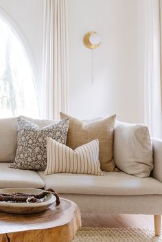 a living room filled with lots of furniture and pillows on top of a wooden table