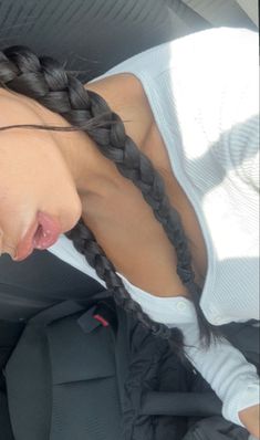 a woman with braids sitting in the back seat of a car