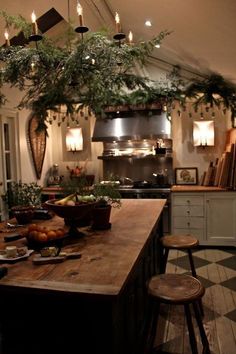 a kitchen filled with lots of counter top space and lights hanging from the ceiling above it