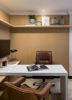 an office with a desk, chair and book on the shelf in front of it