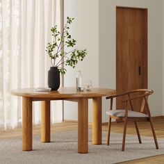 a wooden table with two chairs and a vase on it in front of a door