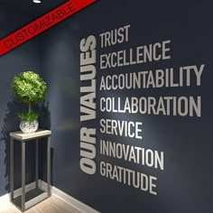 a black wall with words written on it and a plant in the corner next to it