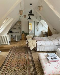 an attic bedroom with two beds and a rug on the floor in front of it