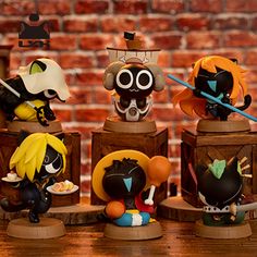 five figurines sitting on top of each other in front of a brick wall