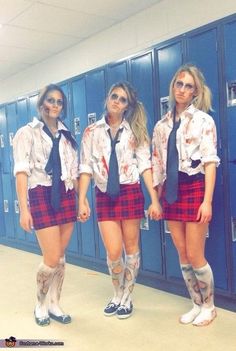 three girls in school uniforms with blood on their shirts and ties, standing in front of lockers