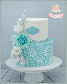 a blue and white cake with flowers on top