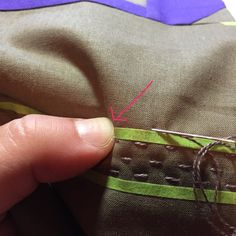 someone is stitching on the side of a piece of fabric