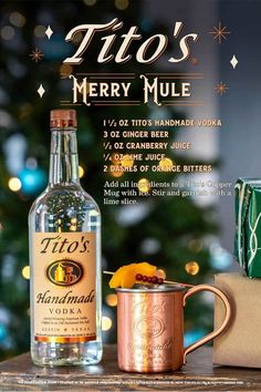 a bottle of alcohol sitting on top of a wooden table next to a mug and christmas tree