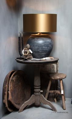 a table with a lamp on it next to a wooden barrel