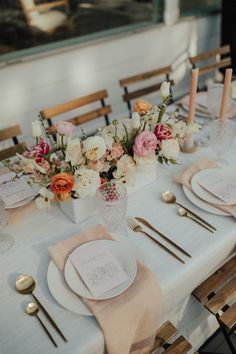 a table set with place settings and flowers