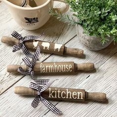 three kitchen utensils are sitting on a table next to a potted plant