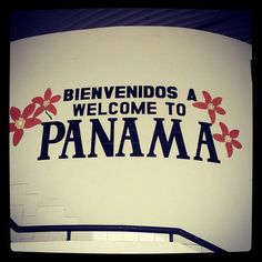 a sign that says welcome to the city of panama, with red flowers on it