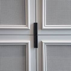 two white doors with black handles on each one and the other side are closed to reveal perforated panels