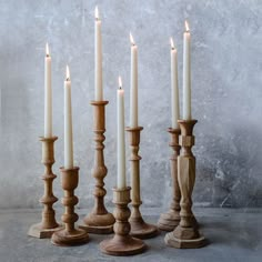 a group of wooden candles sitting next to each other on top of a cement floor