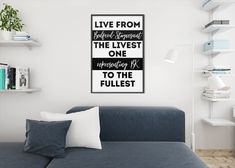 a living room with a couch, bookshelves and a poster on the wall