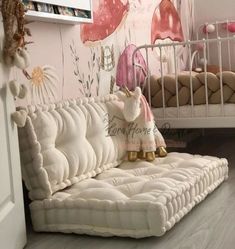 there is a white bed with pink flowers on the wall and a rocking horse next to it