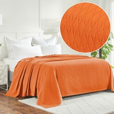 an orange bedspread on a white bed in a bedroom