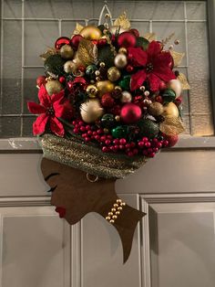 a woman's head is adorned with christmas decorations and ornaments, as she stands in front of a door