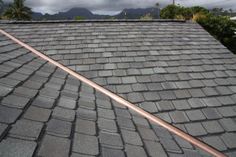 the roof of a house with a large metal pipe sticking out of it's shingles