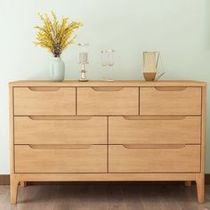 a wooden dresser with two vases on top of it