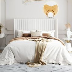 a white bed sitting in a bedroom on top of a rug