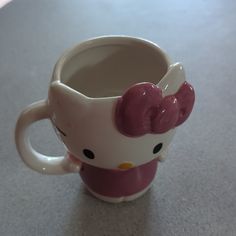 a hello kitty coffee cup sitting on top of a table